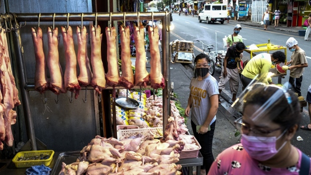 Pork hangs from steel hooks at a roadside market stall in Mandaluyong City, Manila, the Philippines, on Sunday, March 14, 2021. The Philippines is considering tripling imports of pork and has placed a cap on prices after the African swine fever cut supplies of one of the nation's most popular foods.