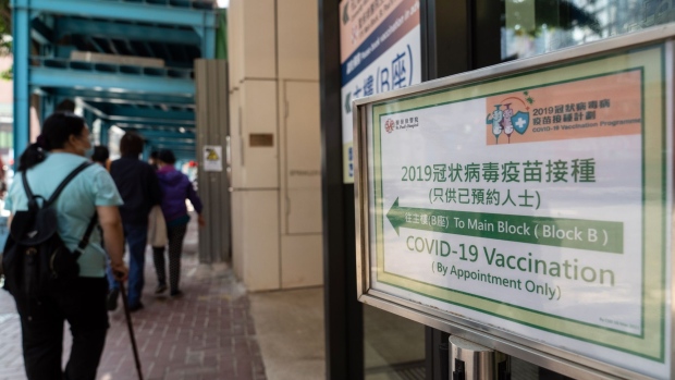 A direction sign outside a community vaccination center administering the BioNTech Covid-19 vaccine imported by Fosun Pharma in Hong Kong, China, on Wednesday, March 17, 2021. Covid-19 vaccination appointments appear to be getting snapped up quickly in Hong Kong, especially in parts of the city impacted by the recent gym outbreak, after the government expanded access to shots in a bid to boost the lackluster inoculation rollout.