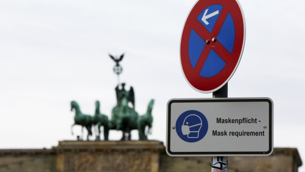 A protective face masks sign near the Brandenburg Gate in Berlin, Germany, on Monday, Dec. 14, 2020. Germany will start a hard lockdown on Wednesday as officials conceded that the coronavirus has spiraled out of control and previous attempts to contain the pandemic were inadequate. Photographer: Liesa Johannssen-Koppitz/Bloomberg