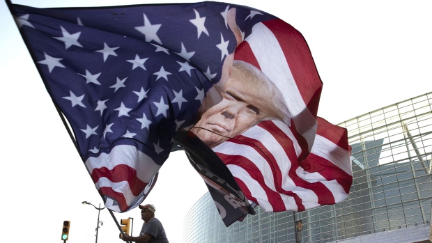 TULSA, OKLAHOMA - JUNE 18: Trump supporter Randall Thom waves a giant Trump flag to passing cars outside the BOK Center June 18, 2020 in Tulsa, Oklahoma. Trump is scheduled to hold his first political rally since the start of the coronavirus pandemic at the BOK Center on Saturday while infection rates in the state of Oklahoma continue to rise. (Photo by Win McNamee/Getty Images) Photographer: Win McNamee/Getty Images North America