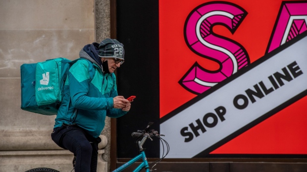 A Deliveroo cyclist checks his phone outside Selfridges on Oxford Street in London, U.K., on Friday, Jan. 15, 2021. Londoners have received one tenth of all vaccine shots administered in England, despite facing a crisis thats pushing the capitals hospitals to the brink of collapse.