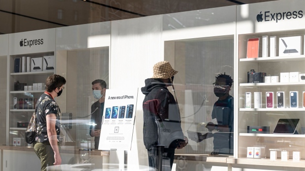 Customers wear protective masks while standing inside an Apple Inc. store in San Francisco, California, U.S., on Wednesday, Feb. 17, 2021. The U.S. economy started 2021 with a bang as retail sales and factory output accelerated and expectations continue to build for another jolt of government stimulus, setting the stage for what could be the best year of economic growth in nearly four decades.