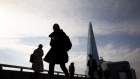 Commuters cross London Bridge in view of The Shard skyscraper in London, U.K., on Monday, March 22, 2021. U.K. Prime Minister Boris Johnson told the country that people 'must' stay at home and certain businesses must close on March 23, 2020. Photographer: Jason Alden/Bloomberg