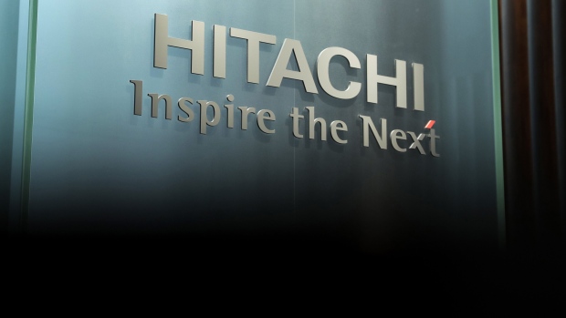 A Hitachi logo sits on display inside the Hitachi Ltd. headquarters. Japanese conglomerate Hitachi confirmed it will halt work on its nuclear power projects in the U.K. and said it will take a one-time charge amid a shift away from reactor sales. Photographer: Kiyoshi Ota/Bloomberg