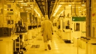 An employee wearing a cleanroom suit walks through the thin film bay inside the GlobalFoundries semiconductor manufacturing facility in Malta, New York, U.S., on Tuesday, March 16, 2021. Production plants for semiconductors have become a focal point as the economic recovery from the pandemic is held back in areas by a shortage of some of the critical electronic components necessary. Photographer: Adam Glanzman/Bloomberg