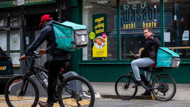 A Deliveroo Holdings Plc logo in the window of a takeaway food restaurant in London, U.K., on Wednesday, March 31, 2021. Food-delivery startup Deliveroo Holdings Plc sank as much as 31% in its London debut after its initial public offering raised 1.5 billion pounds ($2.1 billion), putting pressure on the Citys efforts to boost its profile as a technology and listings hub post-Brexit.
