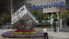 A worker waters the flowers around an installation reading "Follow Our Party Start Your Business" in front of the Tencent Holdings Ltd. headquarters in Shenzhen, China, on Saturday, March 20, 2021.