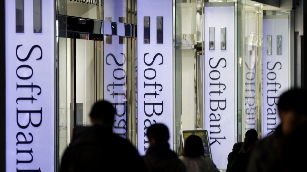 Pedestrians walk past signage for SoftBank Group Corp. outside a store in Tokyo, Japan, on Thursday, Nov. 29, 2018. SoftBank's 2.4 trillion yen ($21 billion) initial public offering of its Japanese telecommunications unit has successfully secured sales for the bulk of its shares to individual investors, people familiar with the matter said.