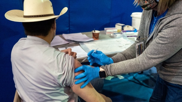 A healthcare worker administers a second dose of the Pfizer-BioNTech Covid-19 vaccine at the University of New Mexico's Gallup campus in Gallup, New Mexico, U.S., on Tuesday, March 23, 2021. Three months into the vaccination campaign in the Navajo Nation, about 70% of the area's user population-people who have visited a health care facility in the last three years-has received at least one dose of the vaccine. Photographer: Cate Dingley/Bloomberg