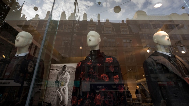 Mannequins stand in window of a Hennes & Mauritz AB (H&M) clothing store in London.