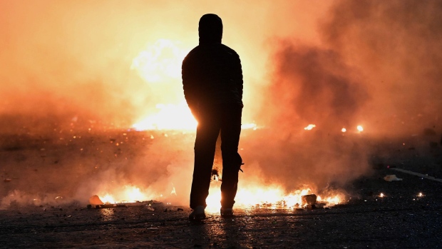BELFAST, NORTHERN IRELAND - APRIL 07: A person looks on as debris burns during clashes at the Springfield Road/ Lanark Way interface on April 7, 2021 in Belfast, Northern Ireland. (Photo by Charles McQuillan/Getty Images)