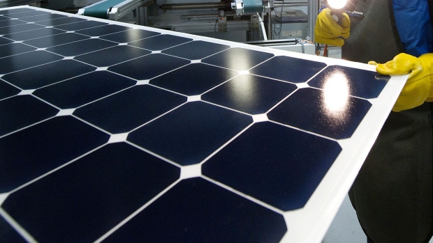 An employee of SunPower Corp. trims the edges and checks solar panels at the SunPower Corp. module manufacturing plant at Flextronics in Milpitas, California, U.S., on Wednesday, Aug. 24, 2011. Photographer: David Paul Morris/Bloomberg