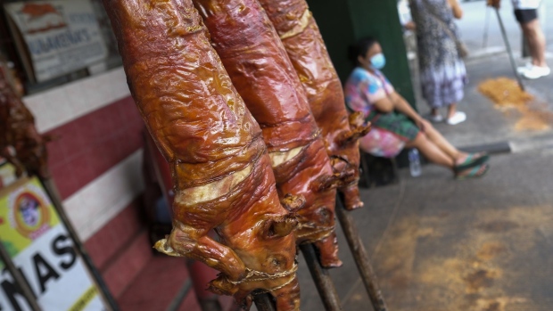 A customer pays for pork at a roadside market stall in Mandaluyong City, Manila, the Philippines, on Sunday, March 14, 2021. The Philippines is considering tripling imports of pork and has placed a cap on prices after the African swine fever cut supplies of one of the nation's most popular foods.