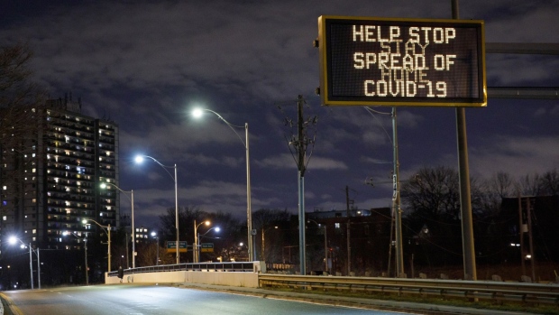 A highway sign encouraging people to stay home in Toronto, Ontario, Canada, on Monday, Nov. 23, 2020. Canada's largest province ordered a lockdown in Toronto and one of its suburbs, a declaration that forces shopping malls, restaurants and other businesses to close their doors to slow a second wave of coronavirus cases.