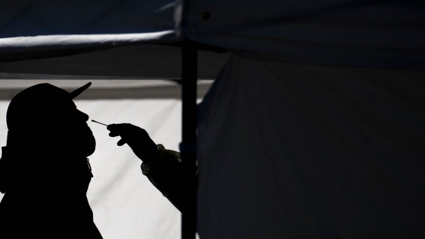 A healthcare worker administers a test at a Covid-19 testing facility outside the Hillcrest Recreational Center in Washington, D.C., U.S., on Tuesday, Nov. 24, 2020. The world is bracing for a new wave of Covid-19 infections, as the coronavirus pandemic has infected more than 59.4 million people and killed more than 1,400,000 globally since late January. Photographer: Sarah Silbiger/Bloomberg