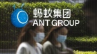 Employees are reflected on a glass panel while walking past a logo at the Ant Group Co. headquarters in Hangzhou, China, on Wednesday, March 24, 2021. China's government has proposed establishing a joint venture with local technology giants that would oversee the lucrative data they collect from hundreds of millions of consumers, according to people familiar with the matter. Photographer: Qilai Shen/Bloomberg