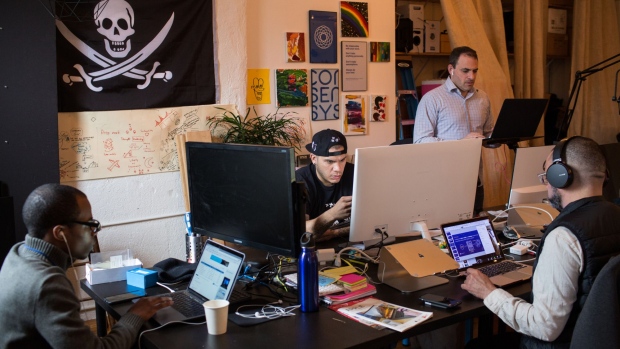 Employees work on computers at the ConsenSys Inc. office in the Brooklyn borough of New York, U.S., on Thursday, March 29, 2018. The employees of ConsenSys, the blockchain startup co-created by Ethereum guru Joseph Lubin, have taken over the space at 49 Bogart Street in the Bushwick neighborhood of Brooklyn.