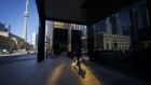 A pedestrian walks on the sidewalk in the financial district of Toronto, Ontario, Canada, on Friday, May 22, 2020.