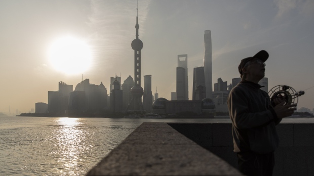 A man flies a kite on the Bund as the Lujiazui Financial District stands in the background in Shanghai, China, on Saturday, April 10, 2021. China's population is aging more quickly than most of the worlds developed economies due to decades of family planning aimed at halting population growth. Photographer: Qilai Shen/Bloomberg