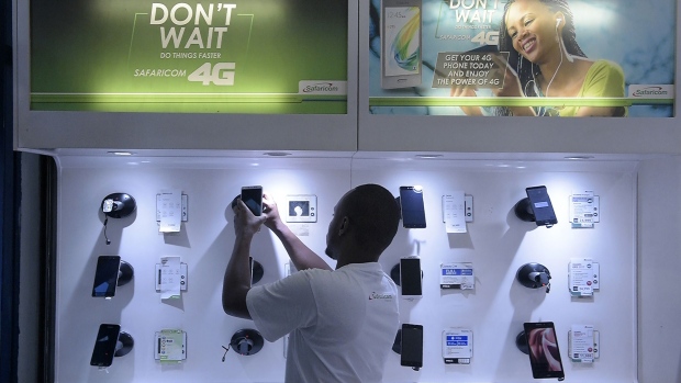 An employee arranges a display of smartphones at a Safaricom shop in Nairobi.