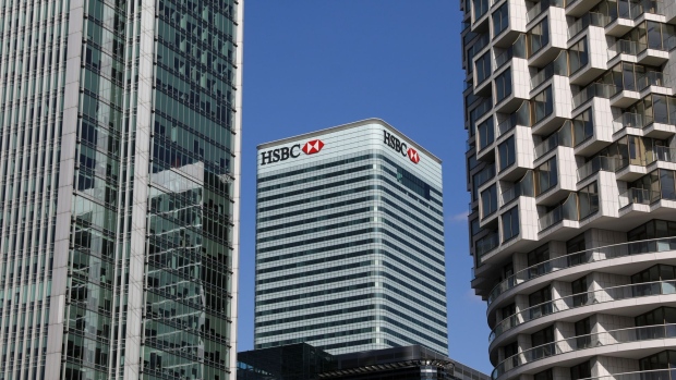 A sign sits on the HSBC Holdings Plc headquarters office building in the Canary Wharf business, financial and shopping district of London, U.K., on Friday, Sept. 18, 2020. After a pause during lockdown, lenders from Citigroup Inc. to HSBC Holdings Plc have restarted cuts, taking gross losses announced this year to a combined 63,785 jobs, according to a Bloomberg analysis of filings. Photographer: Simon Dawson/Bloomberg