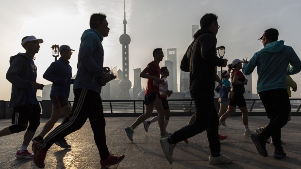 Joggers run along the Bund as the Lujiazui Financial District stands in the background in Shanghai, China, on Saturday, April 10, 2021. China's population is aging more quickly than most of the worlds developed economies due to decades of family planning aimed at halting population growth. Photographer: Qilai Shen/Bloomberg