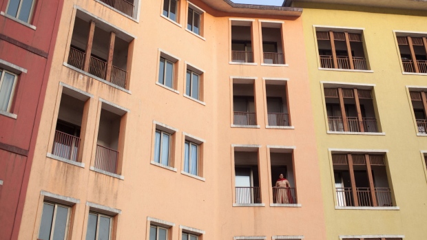 A woman looks out from a residential building in Lavasa, India, on Saturday, May 12, 2018. Hindustan Construction Co. Chairman Ajit Gulabchand is in discussions with as many as three strategic investors, including private equity players and banks, to come up with a solution for Lavasa, a city modeled on the cotton-candy harbor of Italy's Portofino that is now an incomplete shell housing some 10,000 people, and is open to either a partnership, or selling his stake in the project entirely. Photographer: Karen Dias/Bloomberg