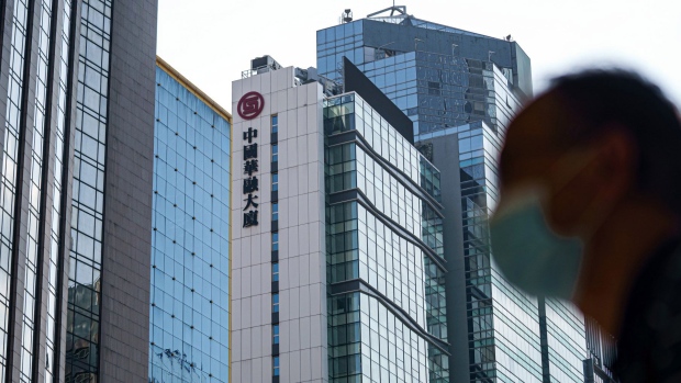 A pedestrian walks past the China Huarong Tower, which houses the headquarters of China Huarong International Holdings Ltd., a unit of China Huarong Asset Management Co., center, in Hong Kong on April 13, 2021.