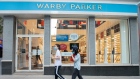 NEW YORK, NEW YORK - AUGUST 08: People wearing masks walk past Warby Parker near Rockefeller Center as the city continues Phase 4 of re-opening following restrictions imposed to slow the spread of coronavirus on August 08, 2020 in New York City