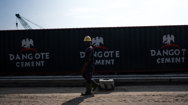 The Dangote Cement Plc logo stands on a barrier at the under-construction Dangote Industries Ltd. oil refinery and fertilizer plant site in the Ibeju Lekki district, outside of Lagos, Nigeria, on Thursday, July 5, 2018. The $10 billion refinery, set to be one of the world’s largest and process 650,000 barrels of crude a day, should be near full capacity by mid-2020, Devakumar Edwin, group executive director at Dangote Industries said in an interview. Photographer: Tom Saater/Bloomberg