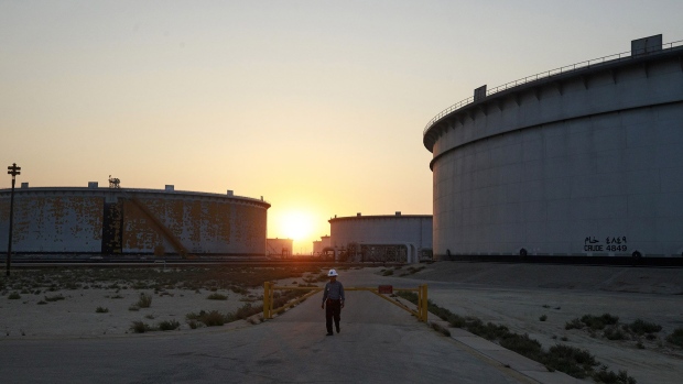 An employee walks past crude oil storage tanks at the Juaymah Tank Farm in Saudi Aramco's Ras Tanura oil refinery and oil terminal in Ras Tanura, Saudi Arabia, on Monday, Oct. 1, 2018. Saudi Arabia is seeking to transform its crude-dependent economy by developing new industries, and is pushing into petrochemicals as a way to earn more from its energy deposits. Photographer: Bloomberg/Bloomberg