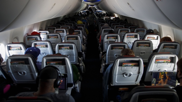 Passengers sit during an American Airlines flight departing from Los Angeles International Airport on June 13. Photographer: Patrick T. Fallon/Bloomberg