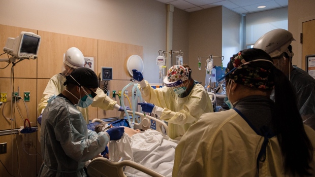 Health care workers prepare to prone a patient in the Covid-19 Intensive Care Unit (ICU) overflow area at Providence Holy Cross Medical Center in Mission Hills, California, U.S., on Friday, Feb. 5, 2021. California’s 14-day positive test rate dropped to 6.6%, down from 12.7% a month ago and the lowest since Nov. 30.