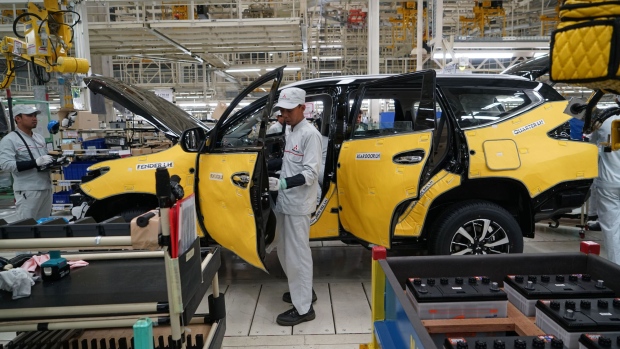 Employees work on a Mitsubishi Motors Corp. sports utility vehicle (SUV) on a production line at the company's plant in Cikarang, Indonesia, on Tuesday, April 25, 2017. Mitsubishi Motors may supply its new multipurpose vehicle to Nissan Motor Co. in Indonesia by 2019, as the alliance partners explore ways to enhance cooperation and exploit synergies. Photographer: Dimas Ardian/Bloomberg