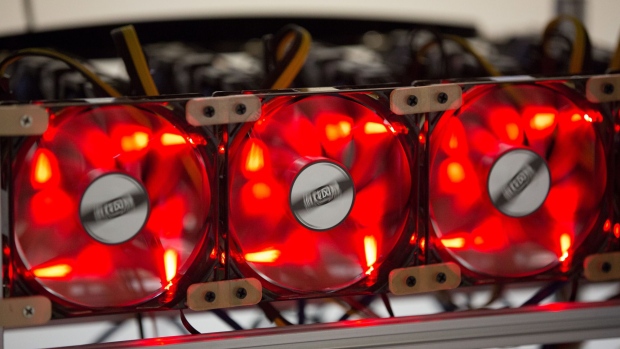 Red light illuminates cooling fans used to cool cryptocurrency mining rigs at the SberBit mining 'hotel' in Moscow, Russia. Photographer: Andrey Rudakov/Bloomberg