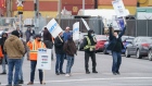 Striking dockworkers from the Port of Montreal walk the picket line.