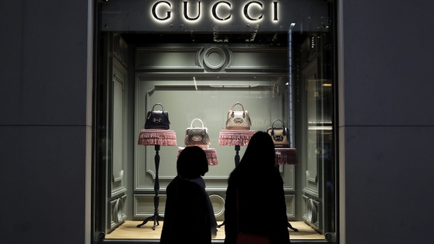 Pedestrians look at Guccio Gucci SpA handbags in the window display of a department store at night in the Ginza district of Tokyo, Japan, on Thursday, Nov. 12, 2020.