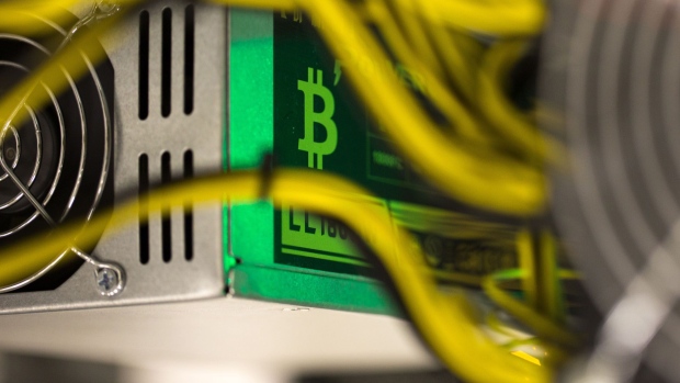 A bitcoin logo sits on a LL 1800W power unit supplying cryptocurrency mining machines at the SberBit mining 'hotel' in Moscow, Russia, on Saturday, Dec. 9, 2017. Futureson the worlds most popular cryptocurrency surged as much as 26 percent in their debut session on Cboe Global Markets Inc.'s exchange, triggering two temporary trading halts designed to calm the market. Photographer: Andrey Rudakov/Bloomberg