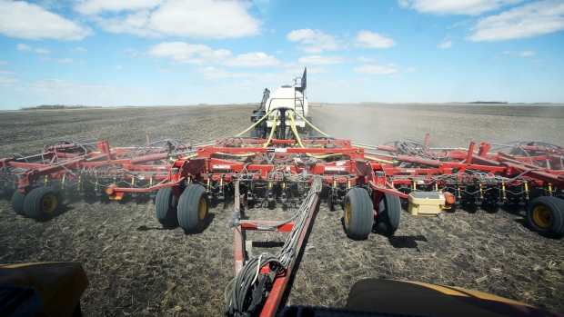 A Bourgault Tillage Tools Ltd. air seeder and air cart are seen though the polarized window of a tractor while planting canola seeds on a farm near St. Francois Xavier, Manitoba, Canada on Thursday, May 9, 2019. Prime Minister Justin Trudeau's government is expanding a loan program for farmers and launching a trade mission to Japan and South Korea as Canadian canola exports get caught up in a diplomatic feud with China. Photographer: Shannon VanRaes/Bloomberg