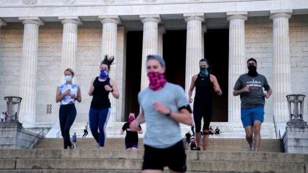 People wear protective masks while exercising at the Lincoln Memorial in Washington, D.C., U.S., on Wednesday, April 21, 2021. Senate Republicans will debate today whether to participate in the new system of earmarking congressional spending, though the outcome likely won't matter to members who are determined to bring funding to their home districts.