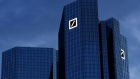 The Deutsche Bank AG logo and a few office windows sit illuminated at the bank's headquarters in the financial district in Frankfurt.