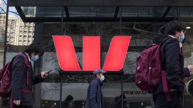 Pedestrians wearing protective face masks walk past a Westpac bank branch in Sydney. Photographer: Brent Lewin/Bloomberg