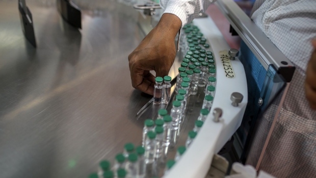 An employee monitors vials of Covishield, the local name for the Covid-19 vaccine developed by AstraZeneca Plc. and the University of Oxford, moving along a conveyor on the production line at the Serum Institute of India Ltd. Hadaspar plant in Pune, Maharashtra, India, on Friday, Jan. 22, 2021. Serum, which is the world's largest vaccine maker by volume, has an agreement with AstraZeneca to produce at least a billion doses.