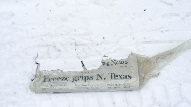 A newspaper buried in snow in McKinney, Texas, U.S., on Tuesday, Feb. 16, 2021. The energy crisis crippling the U.S. showed few signs of abating Tuesday as blackouts left almost 5 million customers without electricity, while refineries and oil wells were shut during unprecedented freezing weather. Photographer: Cooper Neill/Bloomberg