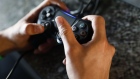 An atendees holds a Sony Corp. Playstation controller while playing a video game during the company's event ahead of the E3 Electronic Entertainment Expo in Los Angeles, California, U.S., on Monday, June 11, 2018. Sony corralled attendees through different venues as they put their new titles on display, including a remastered version of cult favorite Resident Evil 2 and their event finale Spider-Man. Photographer: Patrick T. Fallon/Bloomberg