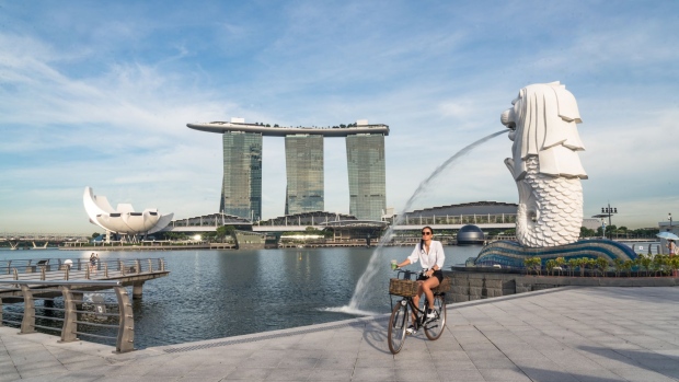 A cyclist rides past the Merlion Statue in a near-empty Merlion Park during the "circuit breaker" lockdown in Singapore, on Wednesday, May 20, 2020. Singapore will allow more businesses to reopen on June 2 -- increasing the active proportion of the economy to three-quarters -- after a nationwide lockdown cut transmission of the coronavirus among citizens and permanent residents. Photographer: Lauryn Ishak/Bloomberg