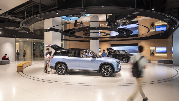 Customers look on as a NIO Inc. ES8 sport utility vehicle (SUV) stands on display inside the Nio House showroom at the Shanghai Tower in Shanghai, China, on Friday, Sept. 14, 2018. NIO last week became the first major electric-car maker to have a U.S. initial public offering since Tesla Inc. in 2010. Photographer: Qilai Shen/Bloomberg