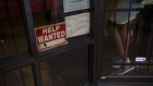 A "Help Wanted" sign outside a restaurant.