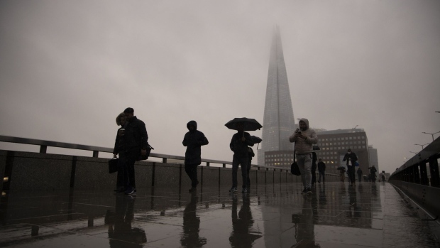 Commuters cross London Bridge in the City of London, U.K., on Monday, Feb. 15, 2021. The U.K. recorded 15 million vaccinations against the coronavirus, a milestone that is set to increase pressure on Prime Minister Boris Johnson to begin reopening the economy. Photographer: Jason Alden/Bloomberg