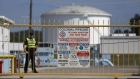 A police officer stands guard inside the gate to the Colonial Pipeline Co. Pelham junction and tank farm in Pelham, Alabama, U.S., on Monday, Sept. 19, 2016. Customers buying gasoline at grocery stores and other independent retailers may pay more than those shopping at name-brand outlets after the biggest gasoline pipeline in the U.S. sprung a leak in Alabama on Sept. 9. Colonial Pipeline Co. has proposed restarting the line on Sept. 22, according to the Alabama Emergency Management Agency. Photographer: Luke Sharrett/Bloomberg